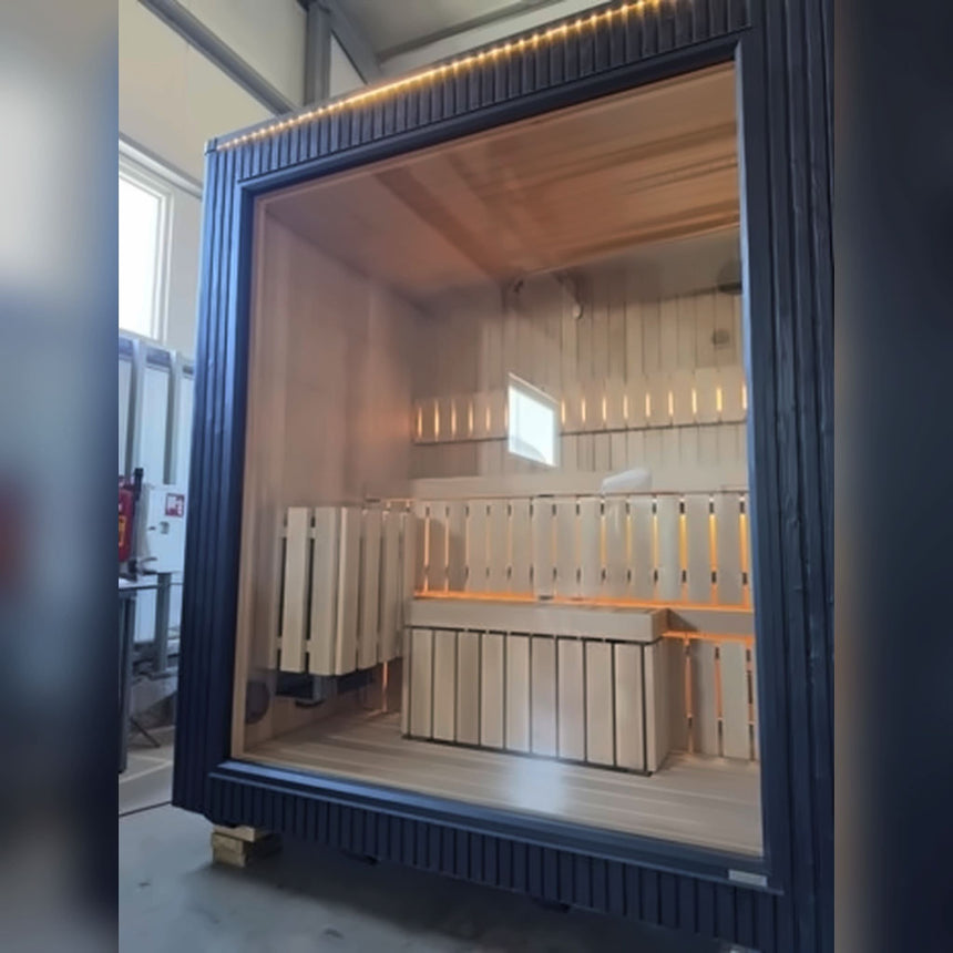 Celsium Jonas Mini outdoor sauna in dark ThermoWood with a large glass front, showing the benches and LED lighting inside