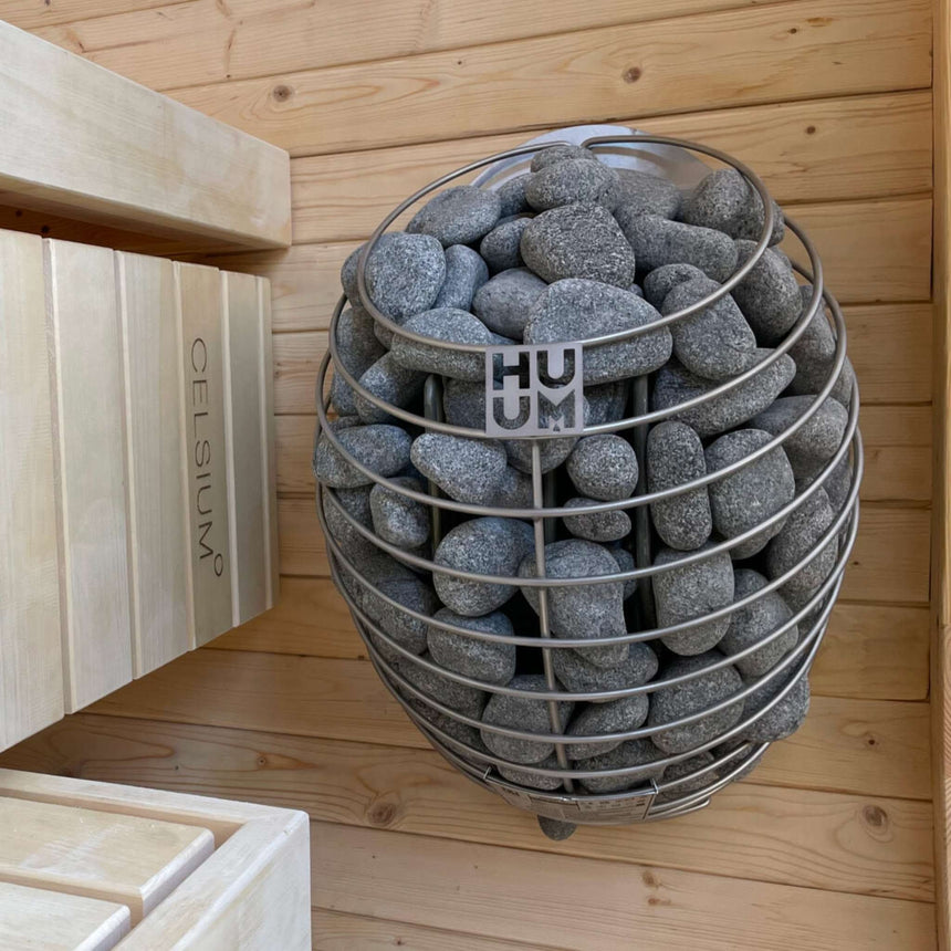 HUUM sauna heater filled with stones beside the bench inside the Celsium Ula Mini