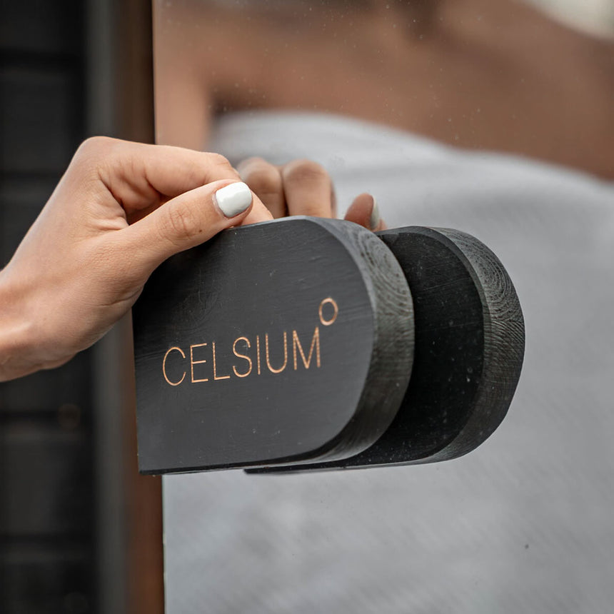 Hand gripping the black wooden Celsium door handle on the Ula Mini