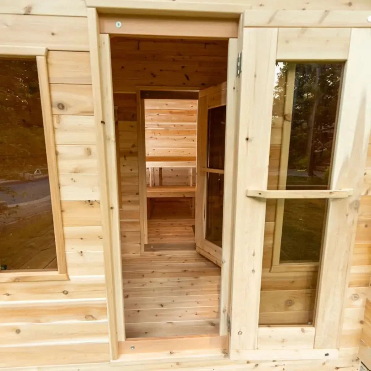 View from the outside of a Dundalk LeisureCraft Canadian Timber Georgian Cabin Sauna with Changeroom (CTC88CE) looking through the doorway and into the sauna.