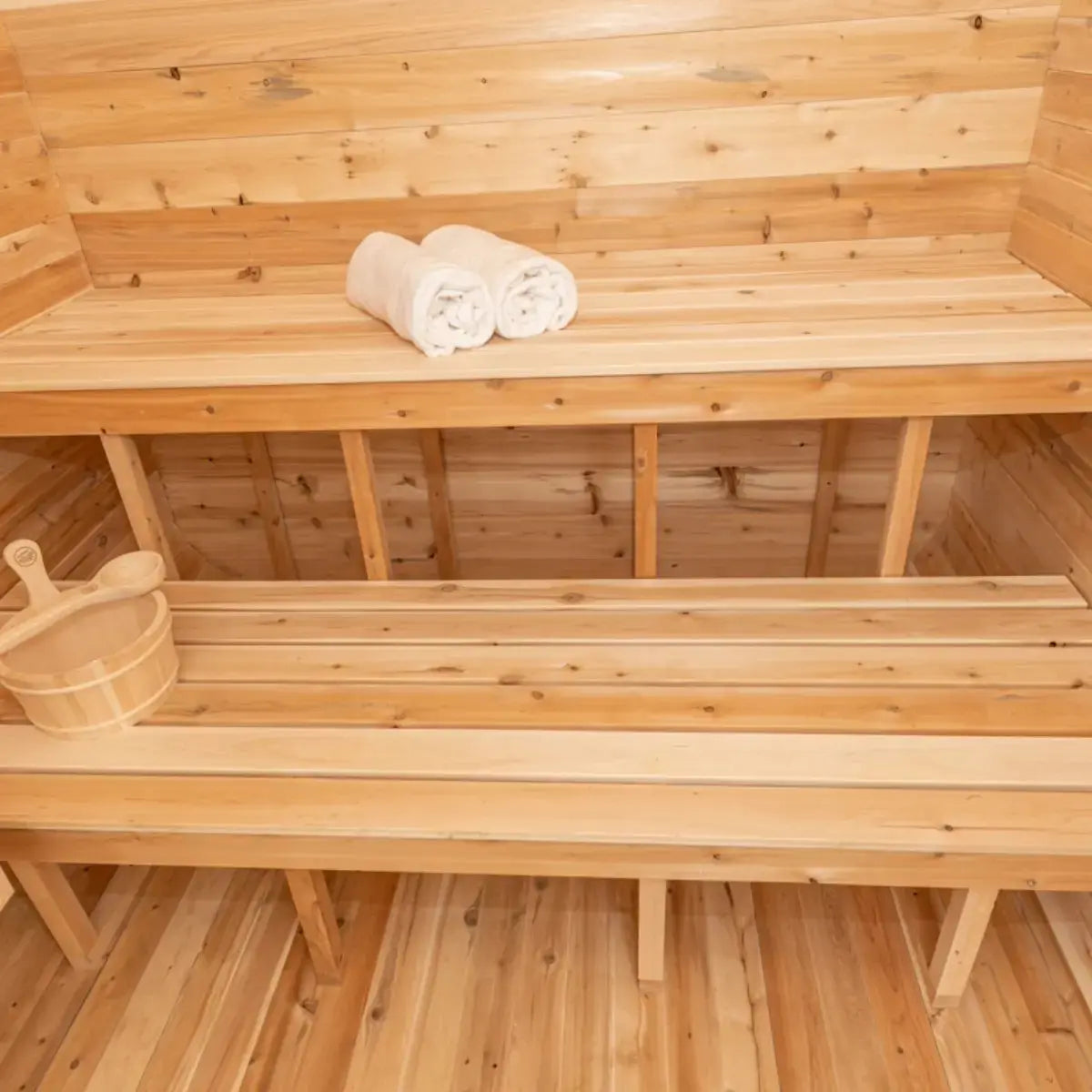 The interior of a Dundalk LeisureCraft Canadian Timber Luna Sauna (CTC22LU), showing the multi-level benches with towels.