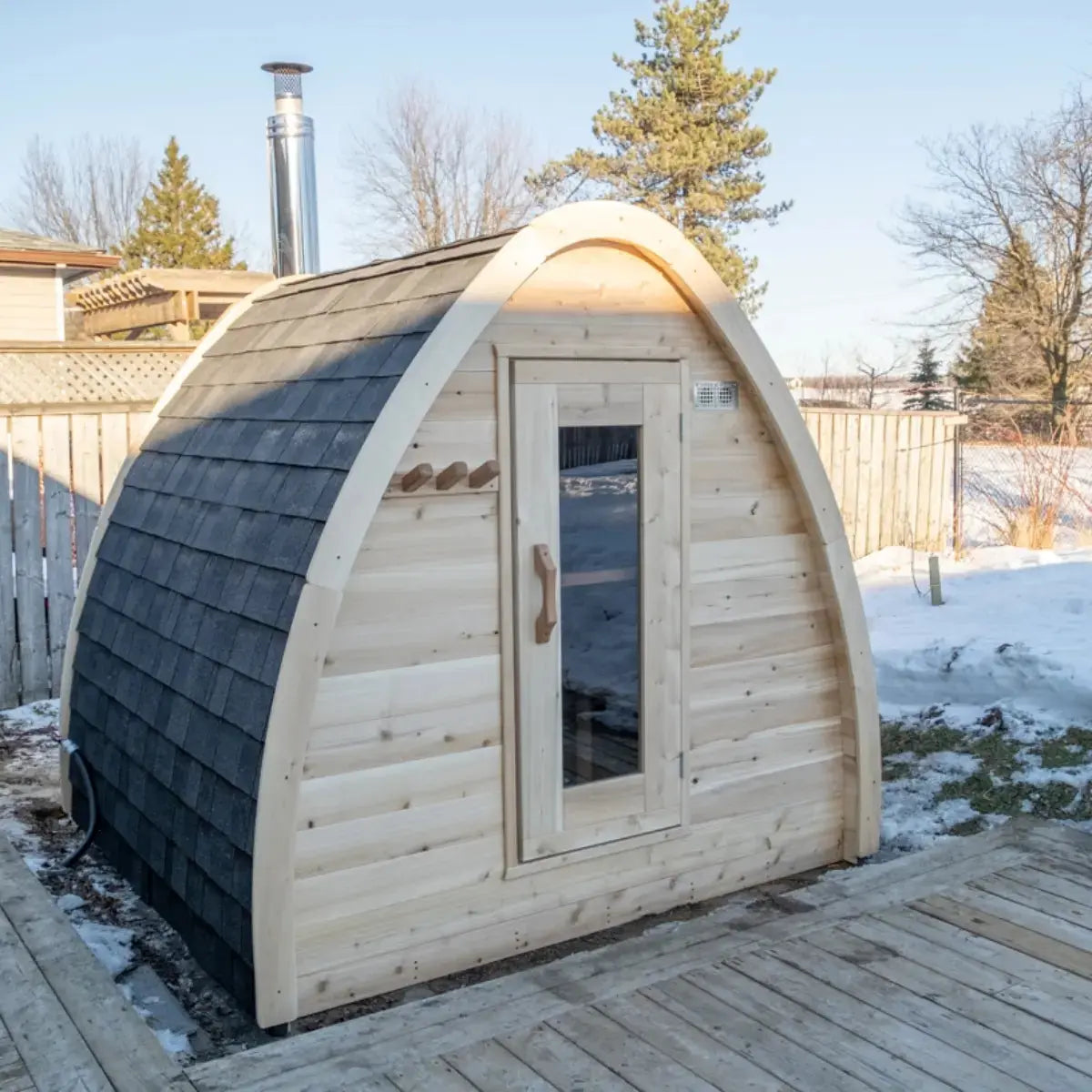 A full exterior view of the Dundalk LeisureCraft Canadian Timber MiniPOD Sauna (CTC77ME), showing its unique pod shape and black asphalt shingles.