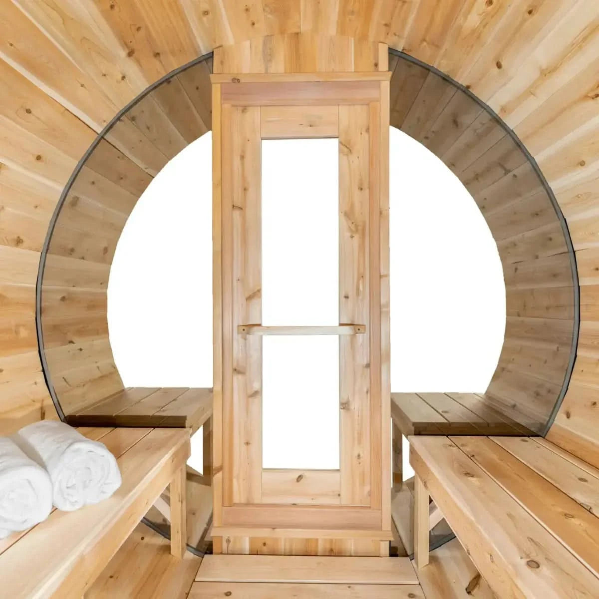 An interior view of the Dundalk Leisure Craft CT Serenity MP Barrel Sauna (CTC2245MPE) looking towards the front door and benches, with two towels placed on the left-hand side.