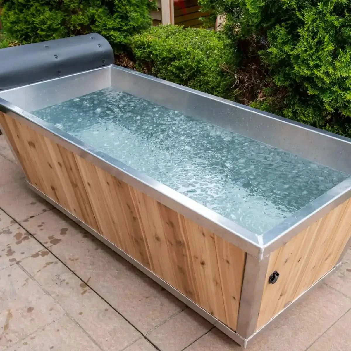 A Dundalk Leisurecraft Polar Plunge Tub (CT362PP) with a white cedar exterior and metal liner, filled with ice water.