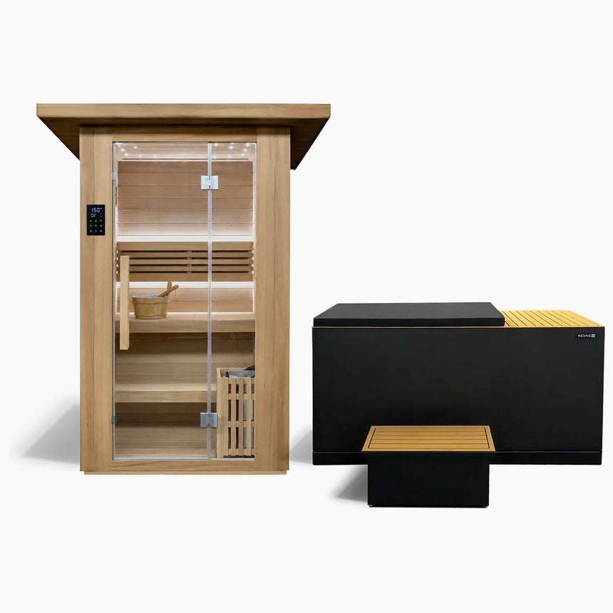 Revive 2 Person Traditional Sauna and Revive Luxury Plunge side by side: the hemlock sauna with its glass door, touchscreen control panel, two-tier benches, bucket and ladle and the heater behind a wooden guard, and the black-cabinet plunge with tan decking, its tub cover on and the matching step in front
