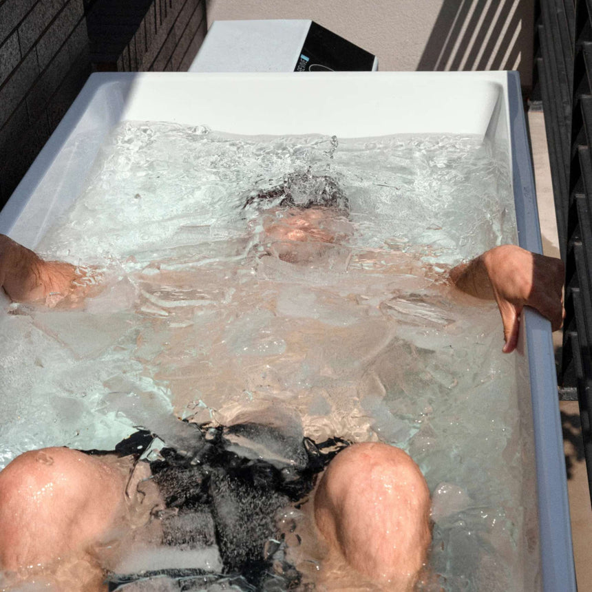 Man fully immersed in icy water in the Revive Acrylic Plunge