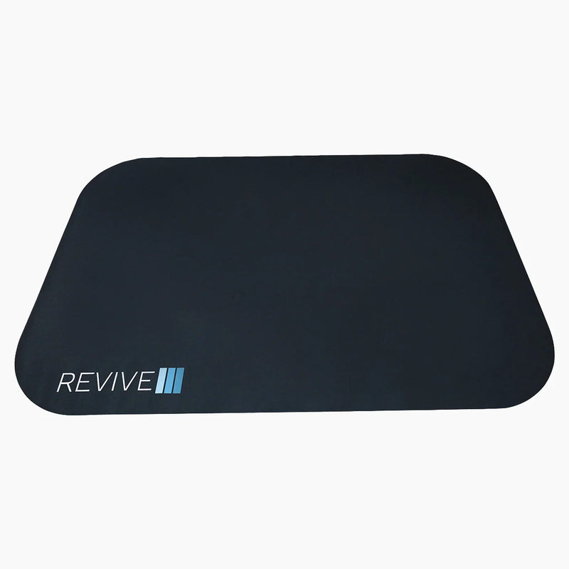 Revive Padded Protective Mat, a black mat with rounded corners and the Revive logo near one corner