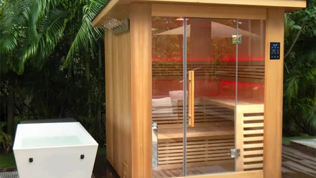 Revive saunas: the Revive 4 Person Traditional Sauna on an outdoor deck with red LED lighting inside, beside a Revive Acrylic Plunge sold separately