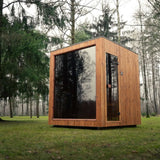 Celsium Jonas Classic outdoor sauna with its large glass front reflecting the surrounding conifer and birch trees