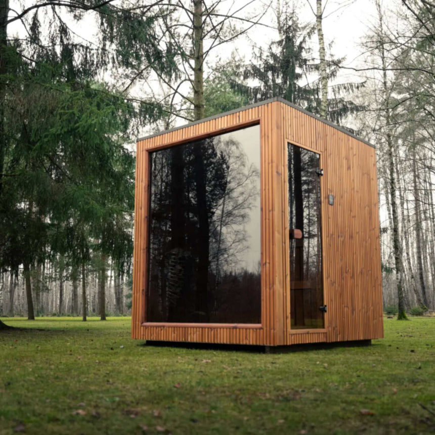 Celsium Jonas Classic outdoor sauna with its large glass front reflecting the surrounding conifer and birch trees