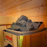 Harvia Vega Compact sauna heater filled with stones, shown inside the Celsium Ula Micro Compact