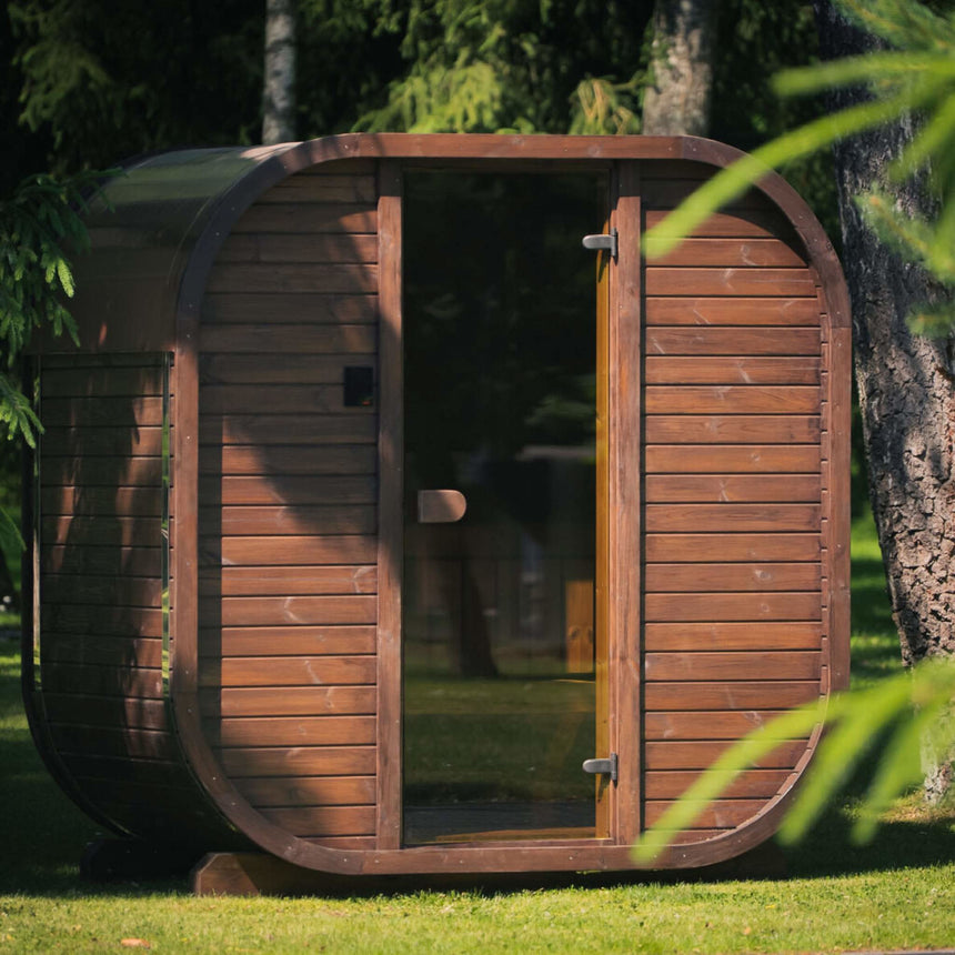 Celsium Ula Mini outdoor sauna in brown ThermoWood, shown with a timber front and a central full-height glass door