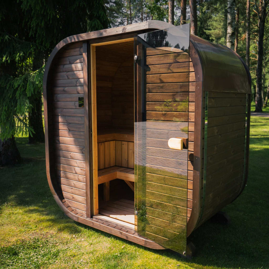 Brown ThermoWood Celsium Ula Mini outdoor sauna with its full-height glass door open on a lawn