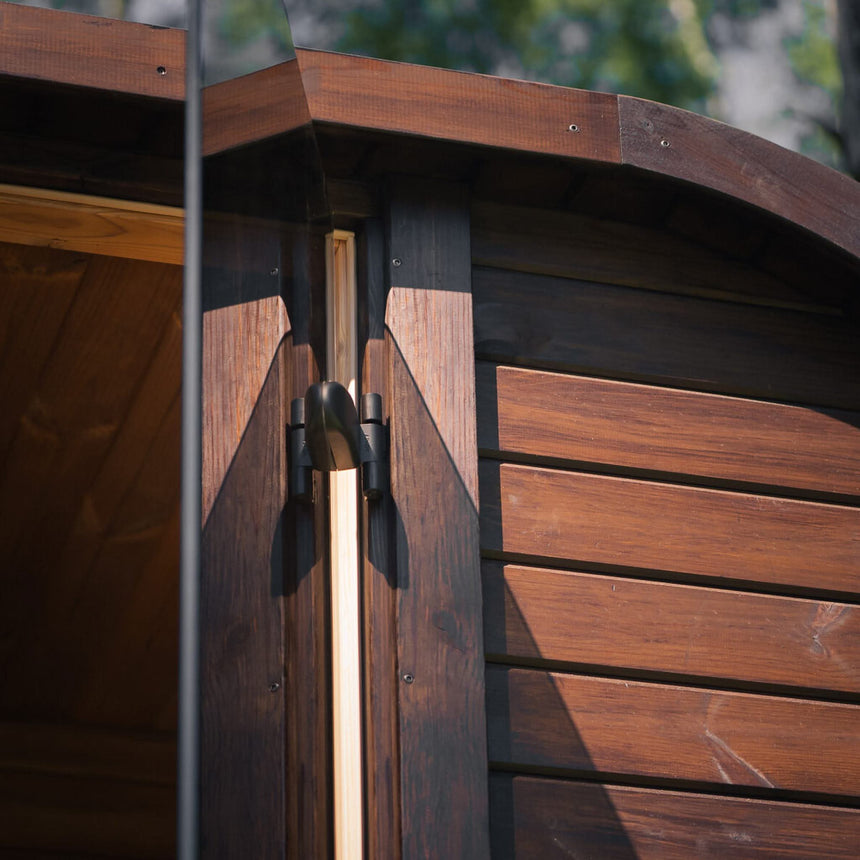 Close-up of a black fitting on the door frame and the brown ThermoWood cladding of the Celsium Ula Mini