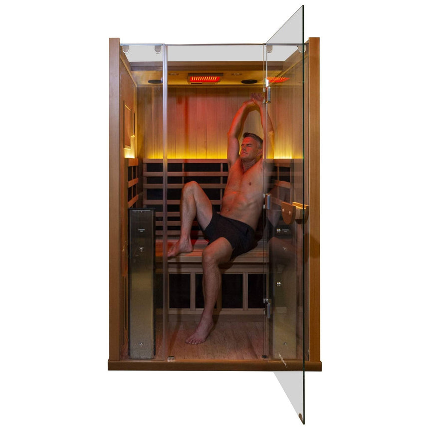Man stretching inside Clearlight Sanctuary 2 full spectrum infrared sauna during wellness session