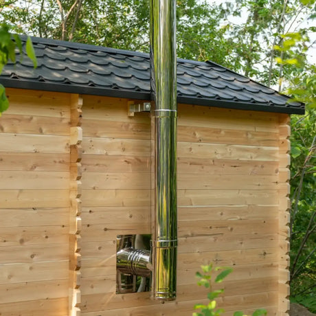 Exterior detail of a Dundalk LeisureCraft Canadian Timber Georgian Cabin Sauna with Changeroom (CTC88CE), showing the black roof and wood stove chimney.