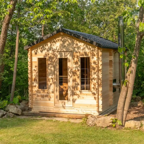 Full exterior view of a Dundalk LeisureCraft Canadian Timber Georgian Cabin Sauna with Changeroom (CTC88CE) set in a wooded area.