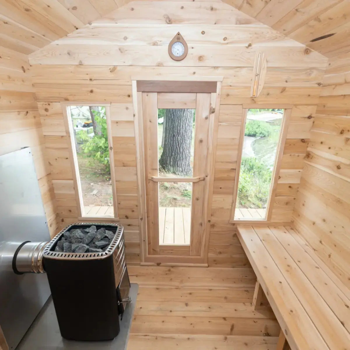 The interior of a Dundalk LeisureCraft CT Georgian Cabin Sauna (CTC88E), showing the glass door and windows that provide natural light and a view of the outdoors.