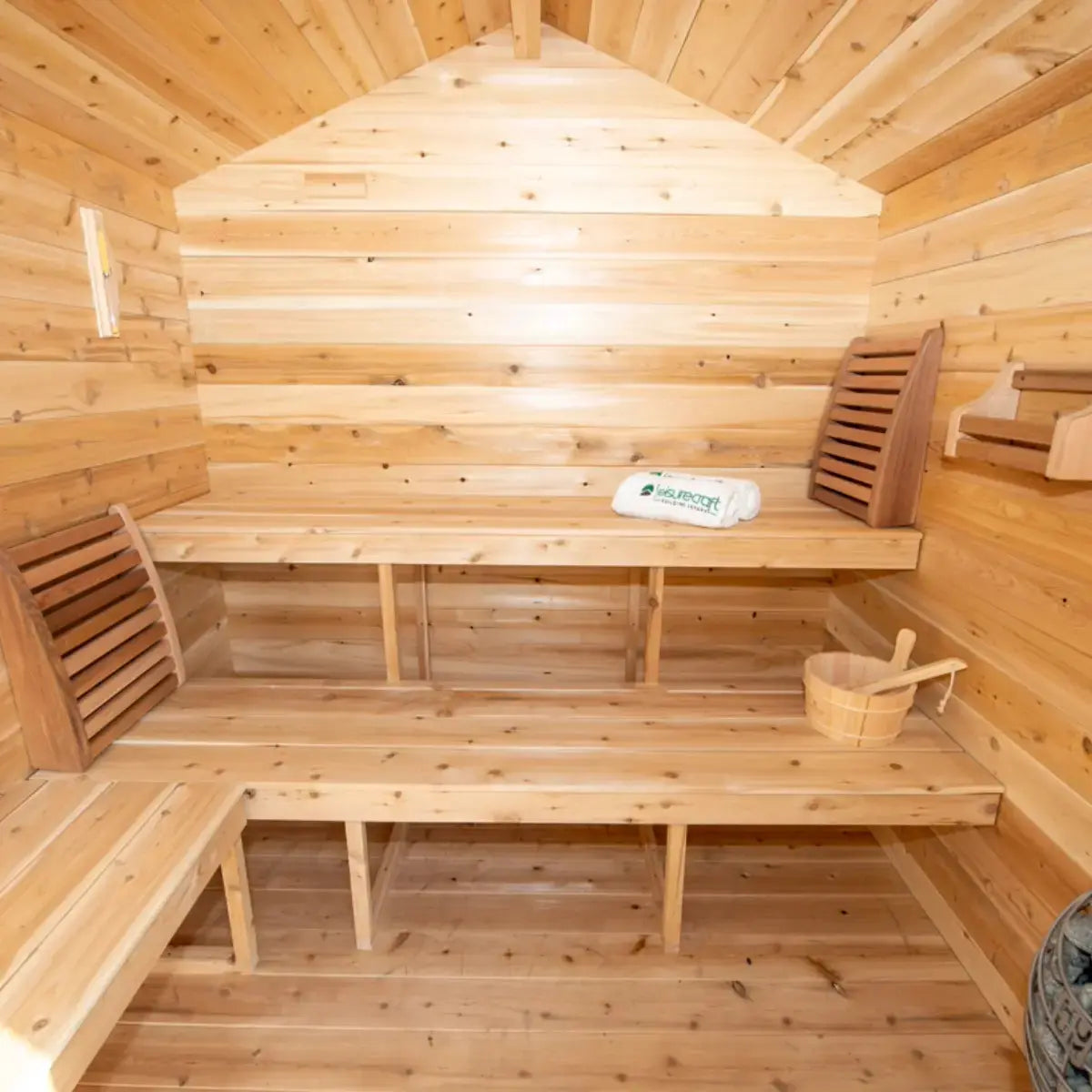 The interior of a Dundalk LeisureCraft CT Georgian Cabin Sauna with Porch (CTC88PE), showcasing the L-shaped cedar benches and accessories.