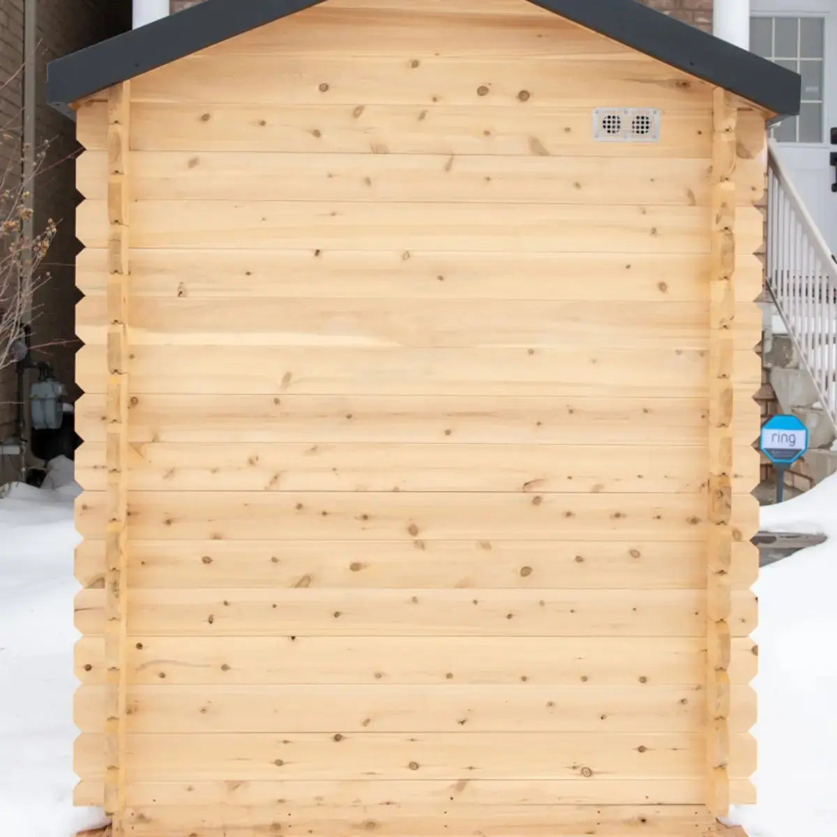 The back exterior of a Dundalk LeisureCraft CT Granby Cabin Sauna (CTC66E), showing the cabin log walls and rear air vents.