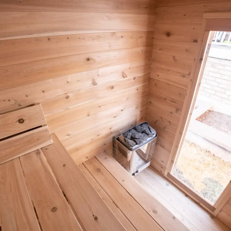 A close-up view of the interior of a Dundalk LeisureCraft CT Granby Cabin Sauna (CTC66E), highlighting the electric sauna heater and wooden benches.