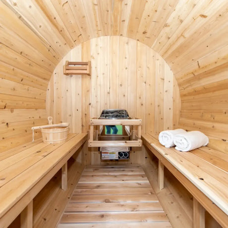 The interior of a Dundalk LeisureCraft Canadian Timber Harmony Barrel Sauna (CTC22E), showing the wooden benches, bucket, and electric heater.