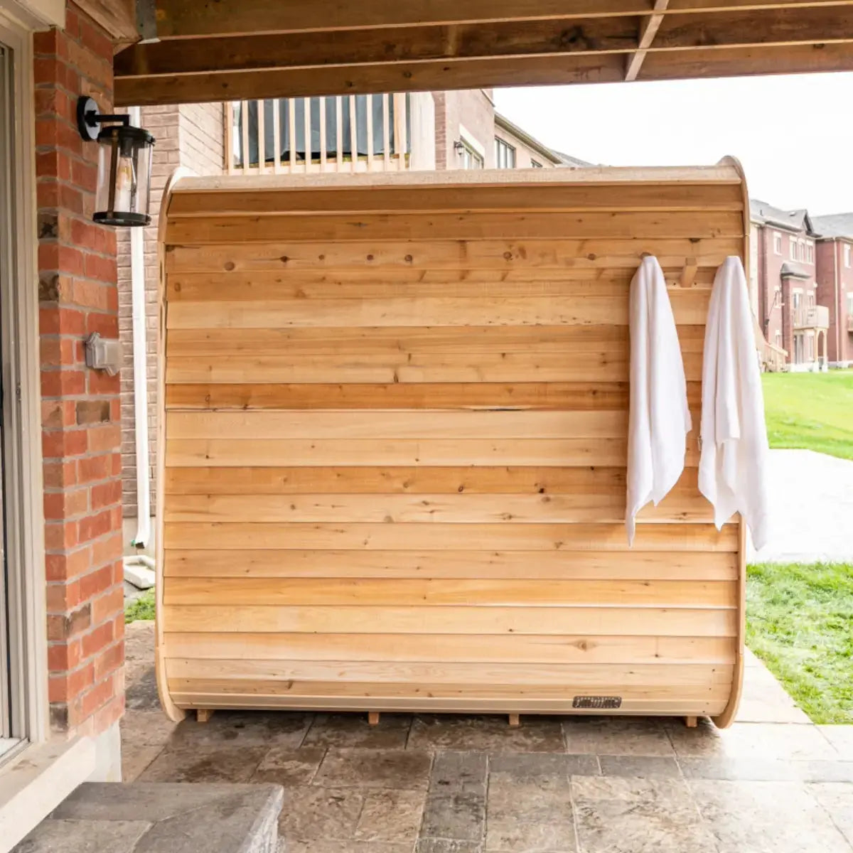 The back exterior of a Dundalk LeisureCraft CT Luna Sauna (CTC22LU) with towels hanging from a built-in towel rack.