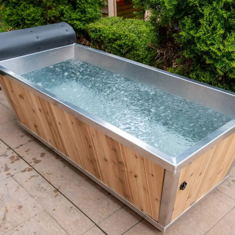 A Dundalk Leisurecraft Polar Plunge Tub (CT362PP) with a white cedar exterior and metal liner, filled with ice water.