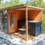 Covered deck of the Revive 4 Person Extended Sauna outdoors, holding the Revive Luxury Plunge with its cover and matching step, with a towel hanging on the deck wall