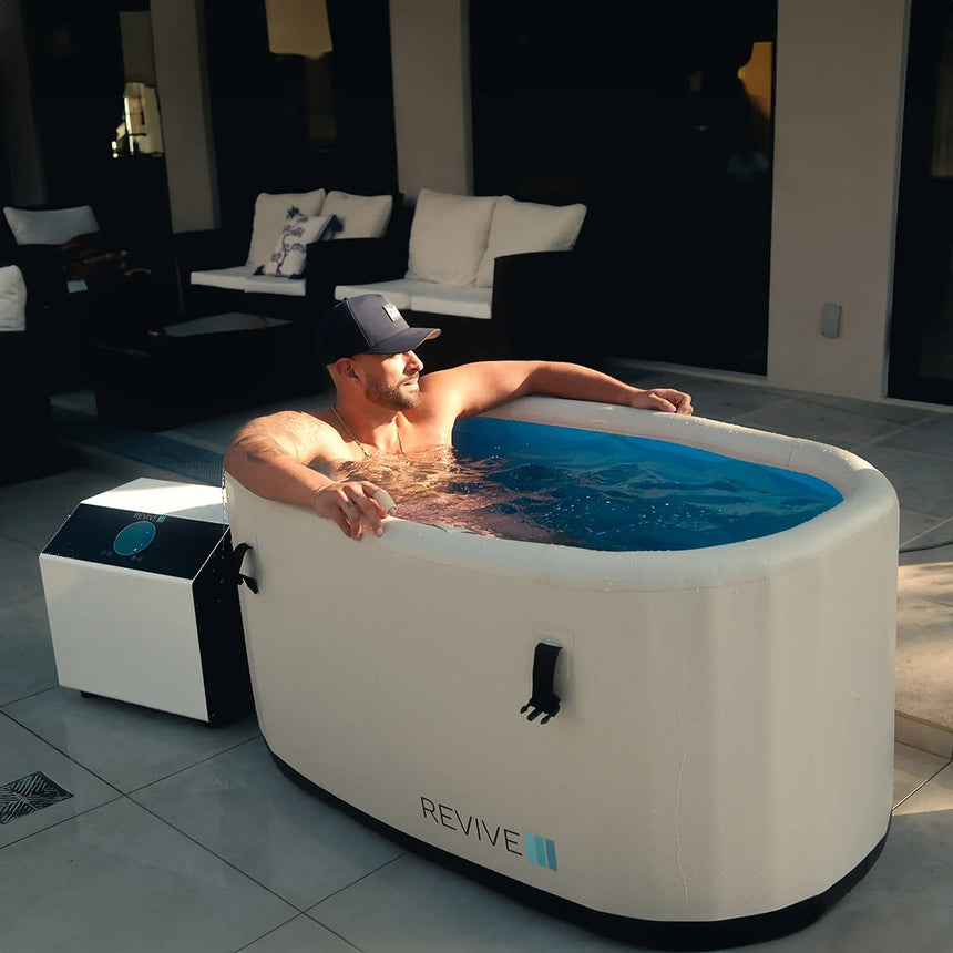 Man soaking in the Revive Inflatable Plunge on an outdoor patio