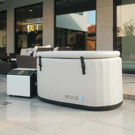 Revive Inflatable Tub with its strapped cover on an outdoor patio, shown with an optional Revive chiller, sold separately