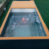Top view of the Revive Luxury Plunge filled with icy water, with tan decking and the LED tub light on