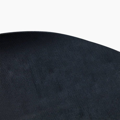 Close-up of the finely textured black surface and rounded edge of the Revive Padded Protective Mat