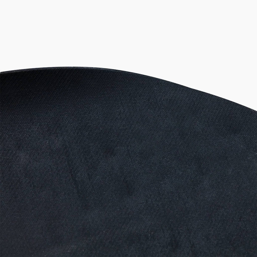 Close-up of the finely textured black surface and rounded edge of the Revive Padded Protective Mat