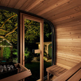 Interior view of SaunaLife Model CL5G 4-person sauna with wood benches, heater, and backyard garden view at night.