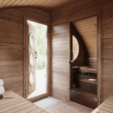 SaunaLife Model G11 8-person Garden Series sauna interior showing thermo-spruce walls, partition wall with bronze glass door and round window.