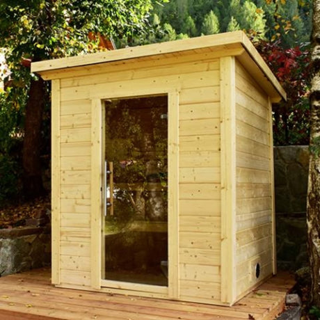 SaunaLife Model G2 4-person outdoor sauna installed in backyard garden with clear tempered glass door and slanted roof.